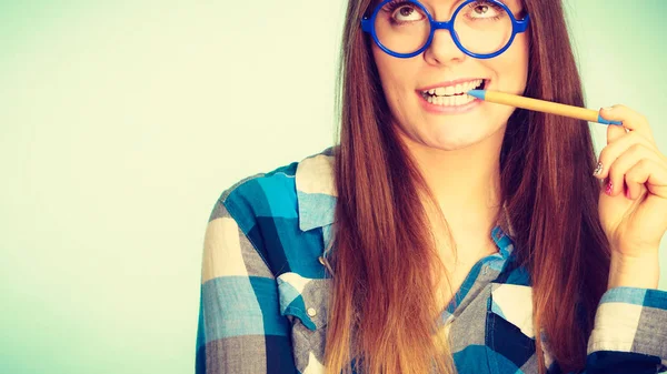 Nerdy šťastná žena v brýlích podržením pera — Stock fotografie