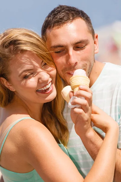 Homem e mulher comendo sorvete na praia — Fotografia de Stock