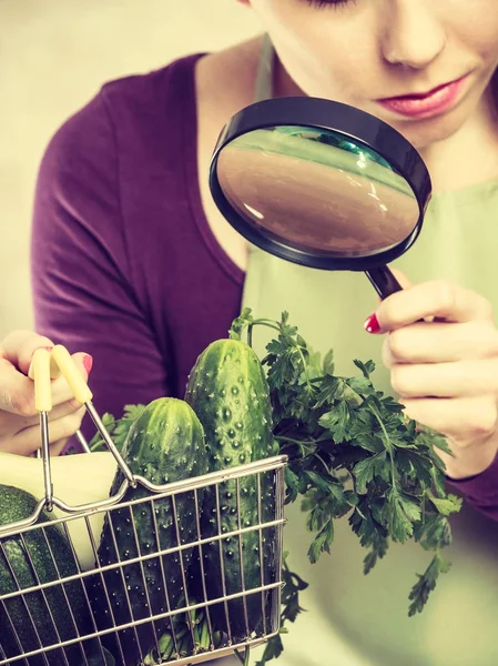 Femme regardant à travers loupe panier de légumes — Photo