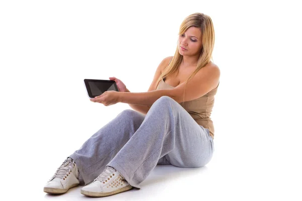 女人在运动服坐控股平板电脑 — 图库照片