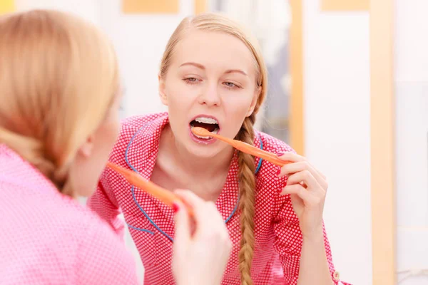 Mulher escovando os dentes de limpeza no banheiro — Fotografia de Stock