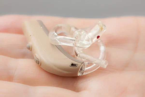 Senior person holding hearing aid closeup — Stock Photo, Image