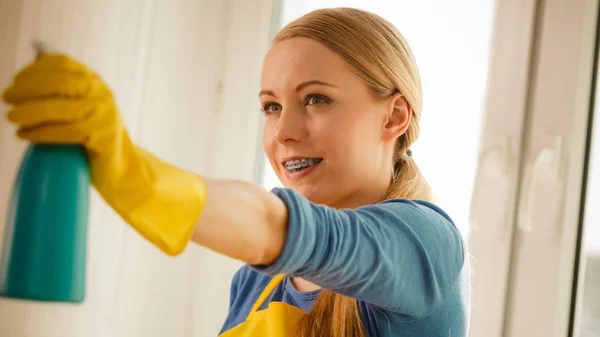 Meisje schoonmaken venster thuis met behulp van wasmiddel doek — Stockfoto