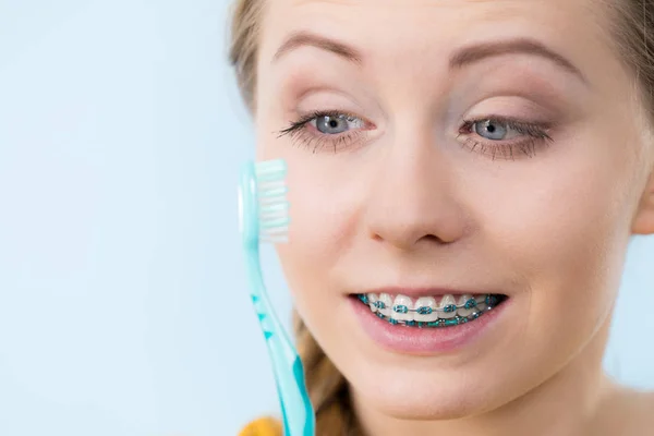 Mulher sorrindo dentes de limpeza com aparelho — Fotografia de Stock