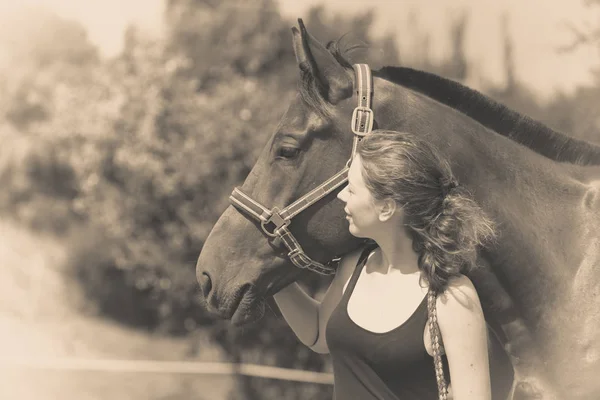 Jóquei menina petting e abraçando cavalo marrom — Fotografia de Stock