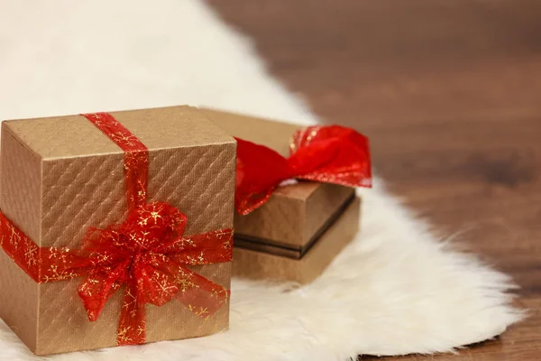 Dos cajas de regalo de oro con lazo de cinta roja —  Fotos de Stock