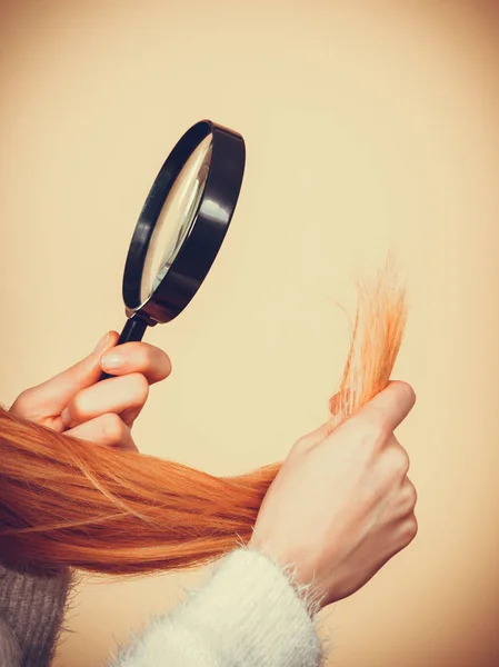 Donna triste guardando le estremità dei capelli danneggiati . — Foto Stock