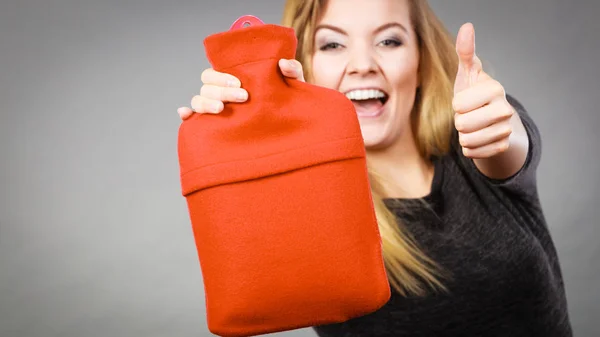 Happy woman holds hot water bottle — Stock Photo, Image