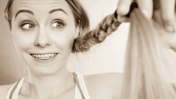 Donna felice guardando le estremità dei capelli — Foto Stock