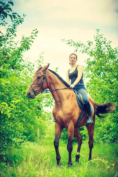 Giovane donna seduta su un cavallo — Foto Stock