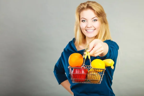 Mulher segurando cesta de compras com frutas dentro — Fotografia de Stock