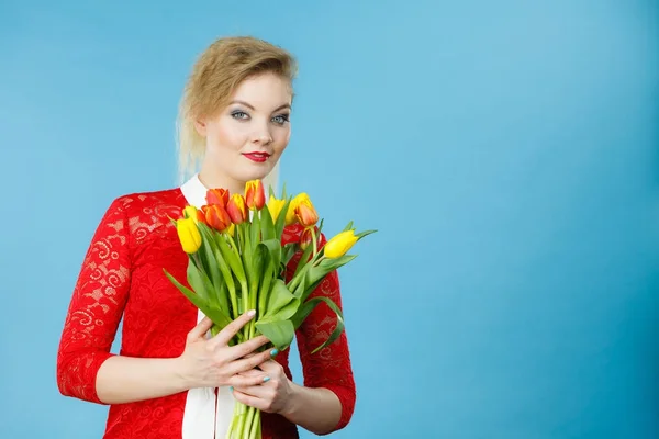 Pretty woman s bandou červené žluté tulipány — Stock fotografie