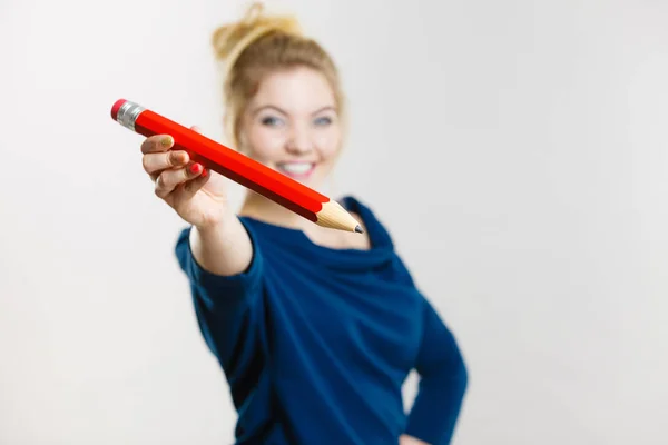 Femme heureuse tenant donnant grand crayon — Photo