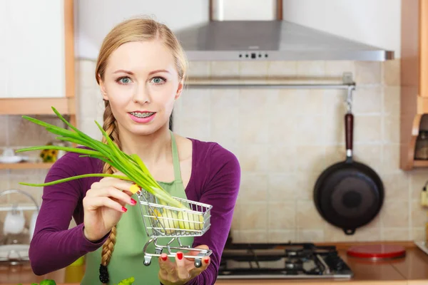 Vrouw met winkelwagentje met bieslook binnen — Stockfoto