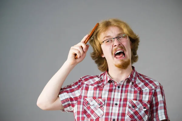 Uomo che ha problemi a spazzolare i capelli — Foto Stock