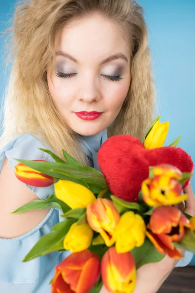 Mulher segura tulipas e coração vermelho — Fotografia de Stock