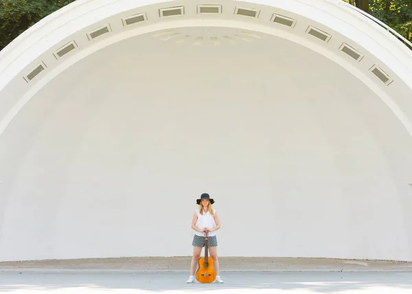 Женщина, играющая на акустической гитаре снаружи — стоковое фото