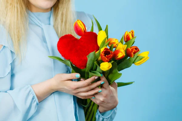 Mujer sostiene tulipanes y corazón rojo — Foto de Stock