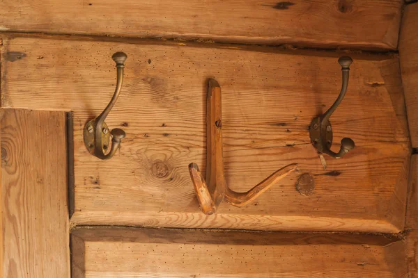 木制墙上的老式铜衣架 — 图库照片
