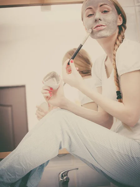 Woman applying with brush clay mud mask to her face — Stock Photo, Image