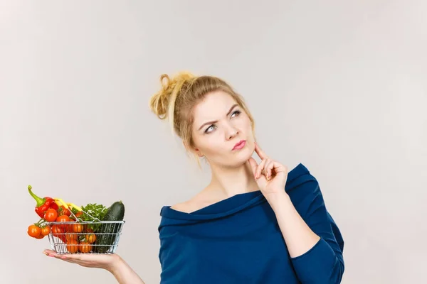 Mulher com legumes, expressão facial pensante — Fotografia de Stock