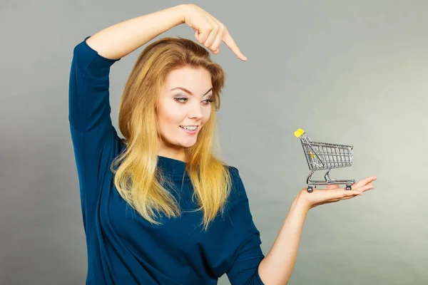 Mujer feliz sosteniendo pequeño carrito de compras pequeño — Foto de Stock