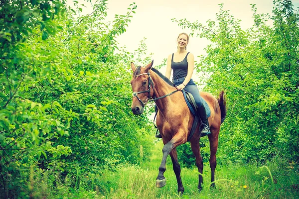 Молодая женщина, сидящая на лошади — стоковое фото