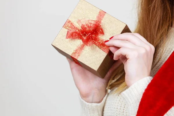 Mujer sosteniendo regalo caja de oro con lazo rojo en las manos —  Fotos de Stock