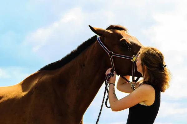 Fantino giovane ragazza baci e abbracci marrone cavallo — Foto Stock