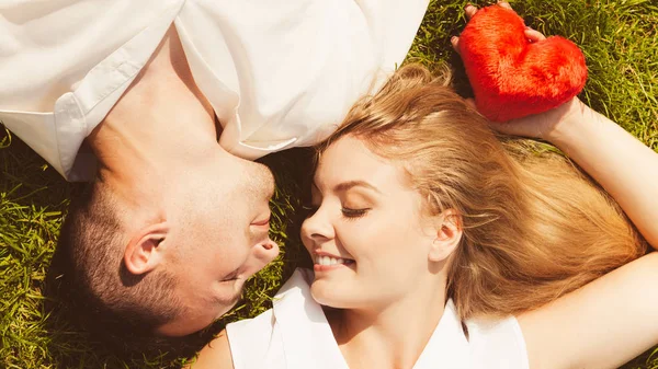 Muž a žena leží na trávě s datum — Stock fotografie