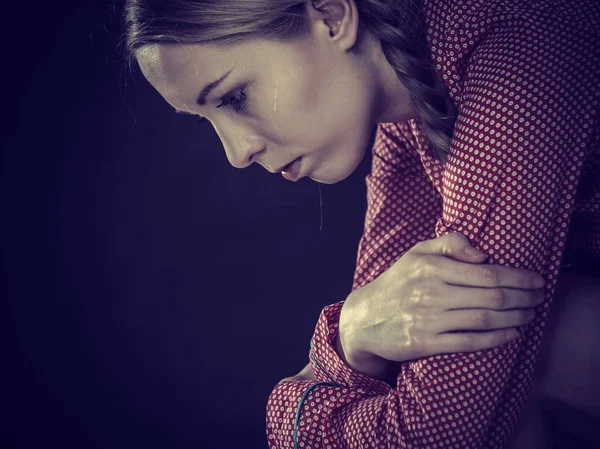 Sad depressed girl sitting huddled — Stock Photo, Image