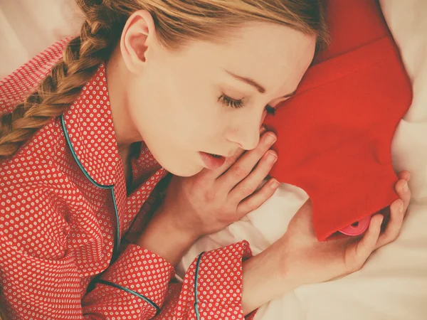 Mulher dormindo com garrafa de água quente vermelha quente — Fotografia de Stock