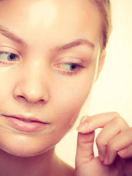 Mujer quitando la máscara de la piel facial . —  Fotos de Stock