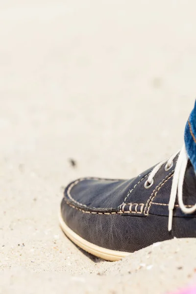 Paar dunkle Turnschuhe am Sandstrand — Stockfoto