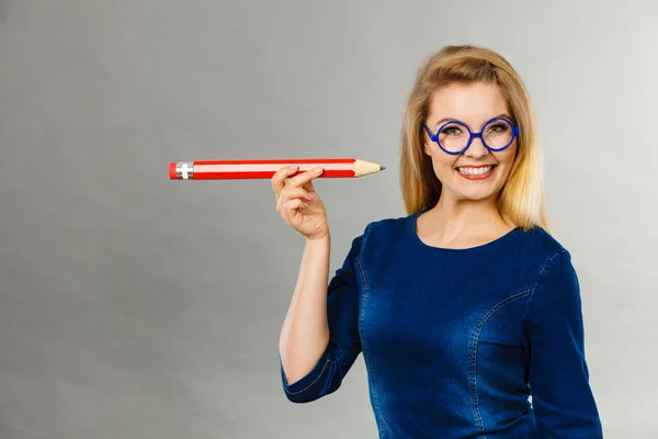 Усміхнена жінка тримає великий олівець в руці — стокове фото