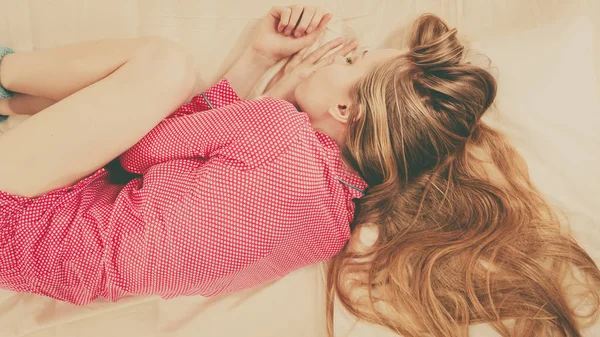 Young woman lying on bed wearing pajamas — Stock Photo, Image