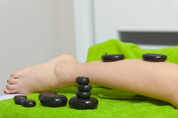 Woman having legs massage with hot stones — Stock Photo, Image