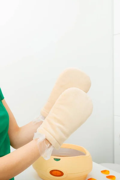 Vrouw paraffinepakkingen hand krijgen bij schoonheidsspecialiste — Stockfoto