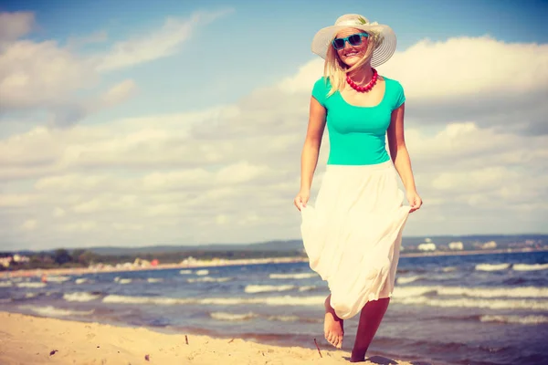 金发女人穿衣服走在海滩上 — 图库照片