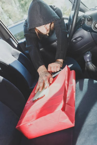 Betörő tolvaj ellopja a smartphone és a táskát az autó — Stock Fotó