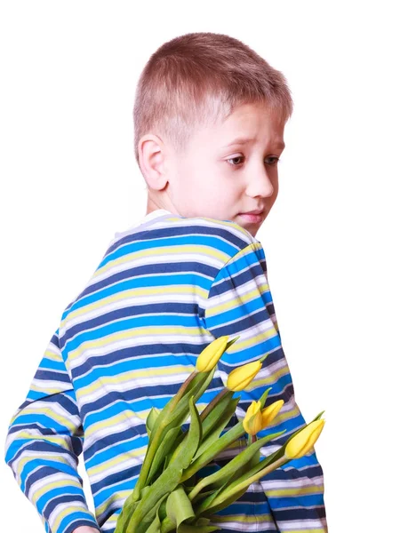 Mały chłopiec trzymać kwiaty za plecami. — Zdjęcie stockowe