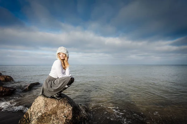 Mujer sobre piedras cerca del mar —  Fotos de Stock