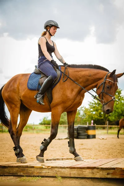 Jockey girl gör häst ridning på landsbygden äng — Stockfoto