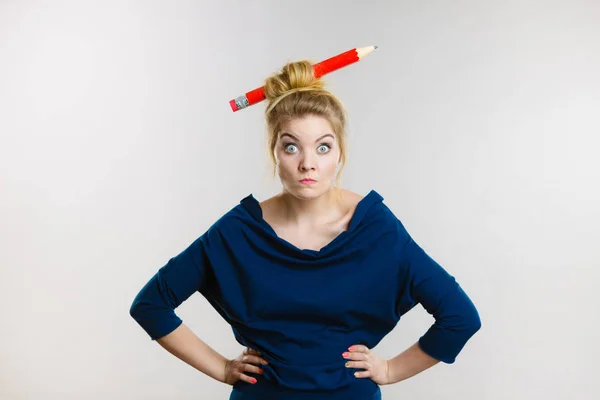 Mujer rubia confundida teniendo lápiz grande en el pelo — Foto de Stock