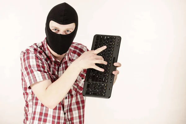 Man dragen balaclava bedrijf toetsenbord — Stockfoto