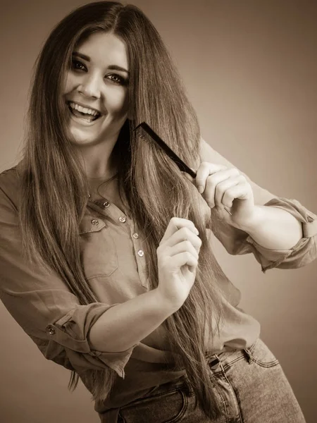 Mujer peinando su cabello castaño — Foto de Stock