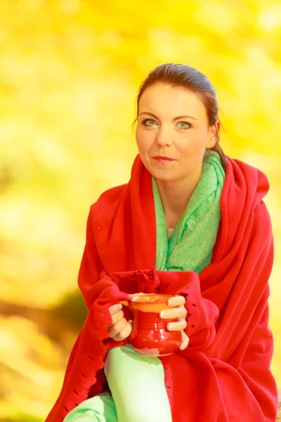 Woman relaxing in park drinking drink from mug — Stock Photo, Image