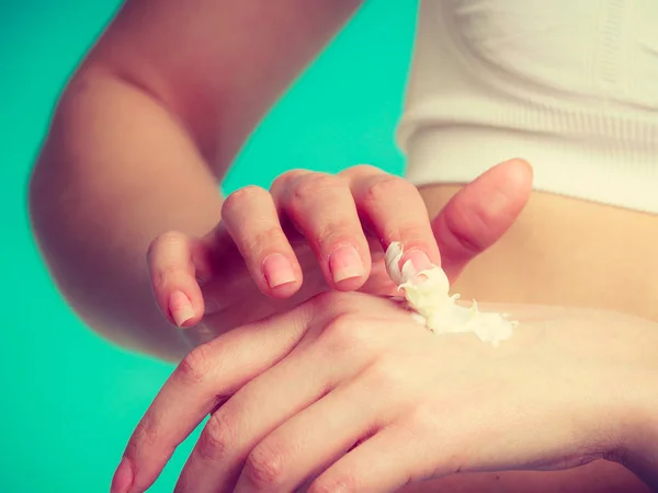 Женщина кладет белый крем на руку — стоковое фото