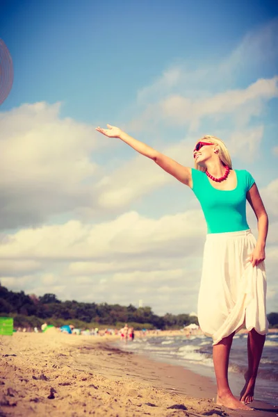 Mujer rubia usando vestido caminando en la playa —  Fotos de Stock