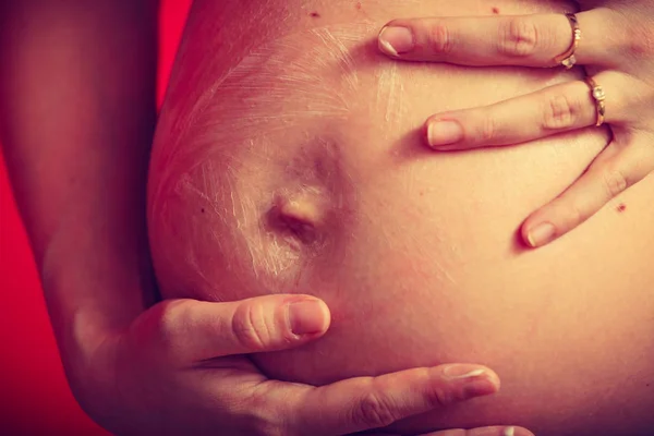 Mulher grávida ter creme na barriga grande — Fotografia de Stock